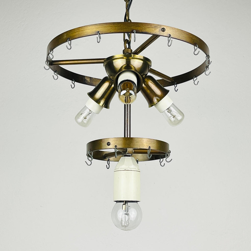 Vintage-style chandelier with brass finish and clear light bulbs on a plain background