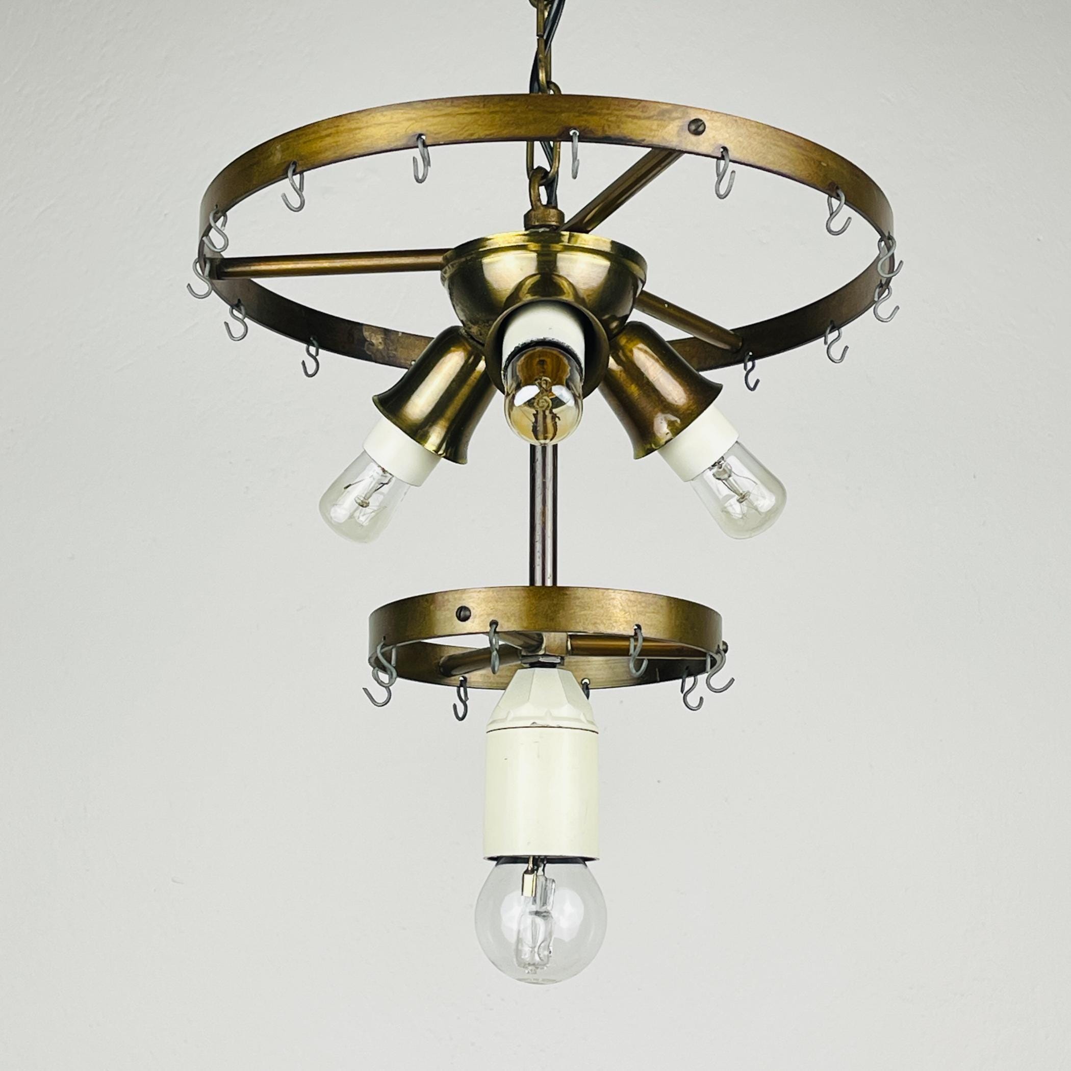 Vintage-style chandelier with brass finish and clear light bulbs on a plain background