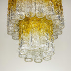 Decorative chandelier with clear and gold glass elements on a plain background