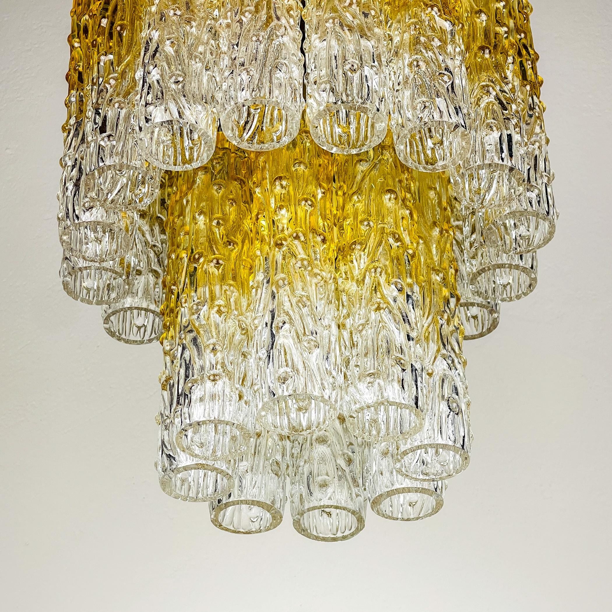 Decorative chandelier with clear and gold glass elements on a plain background
