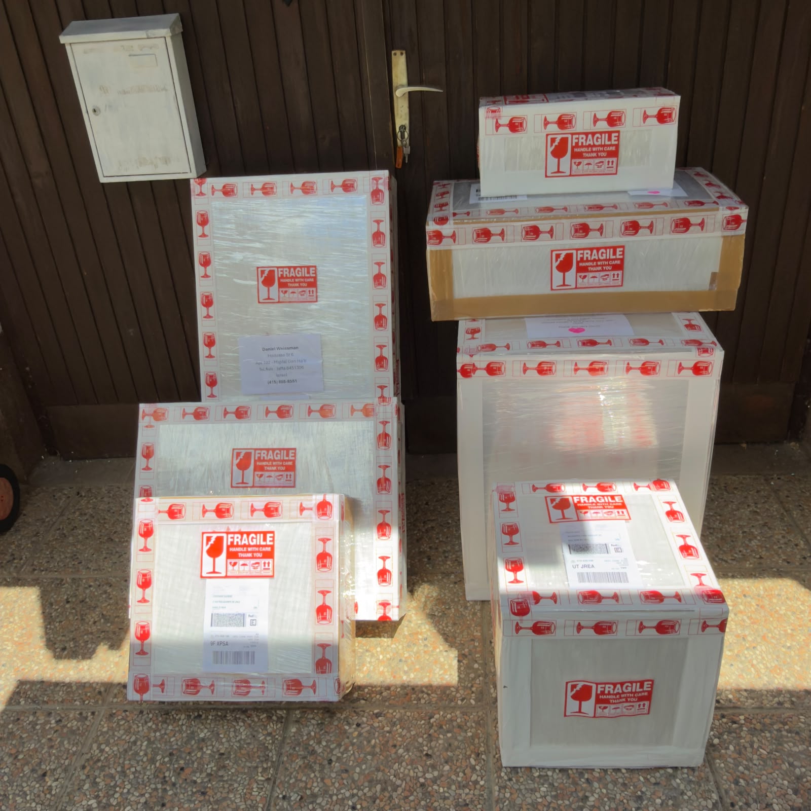 Stack of fragile boxes with labels in front of a door