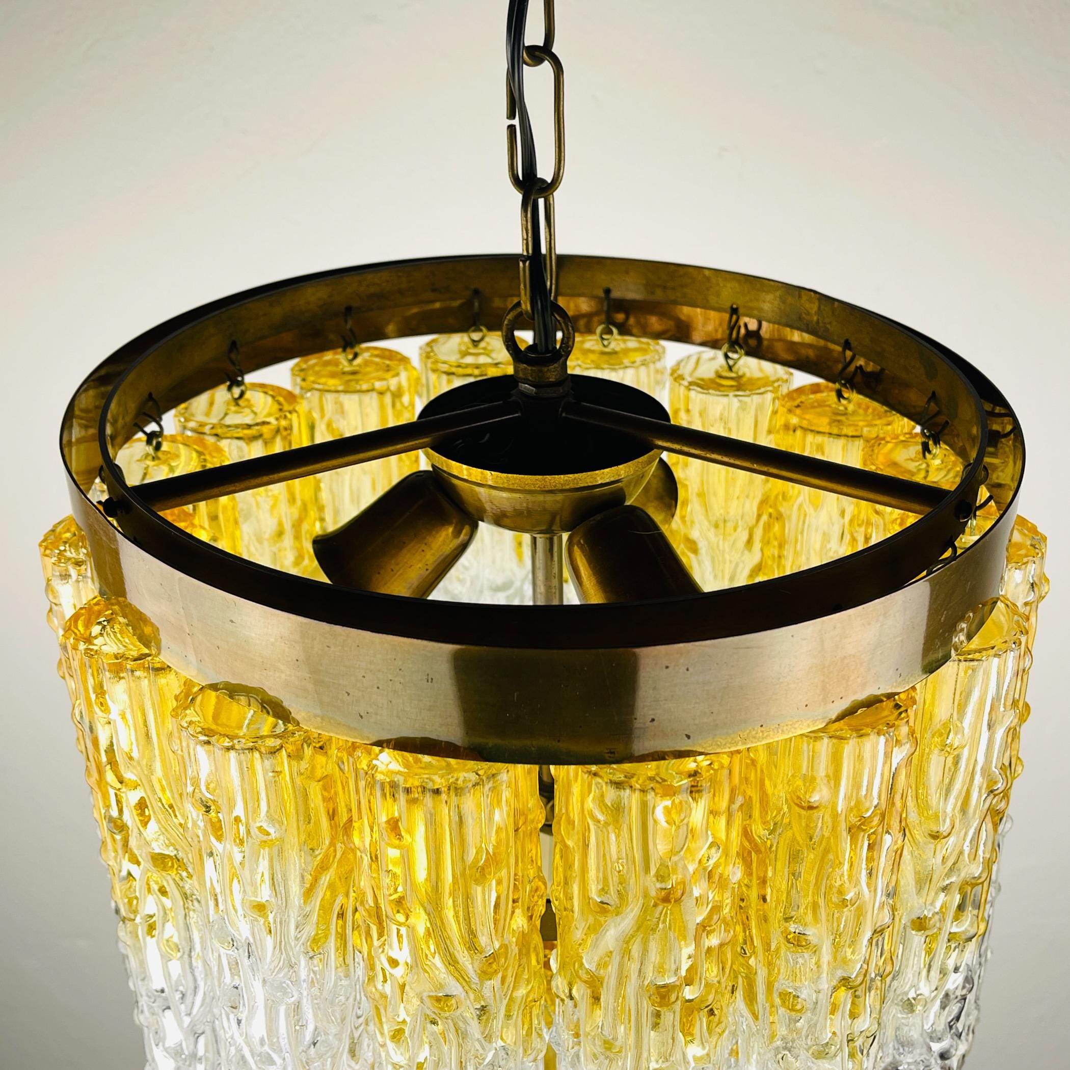 Gold and clear chandelier with textured design on a neutral background