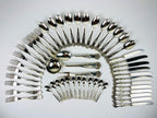 Antique 800 silver cutlery set arranged in a circular pattern on a light gray background, Italian vintage from 1960s